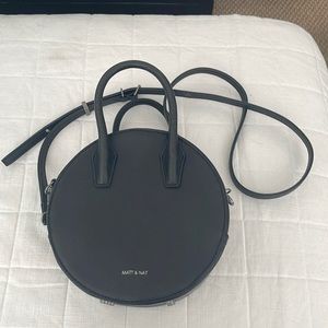 This is a Mat & Nat black crossbody purse with a long strap.